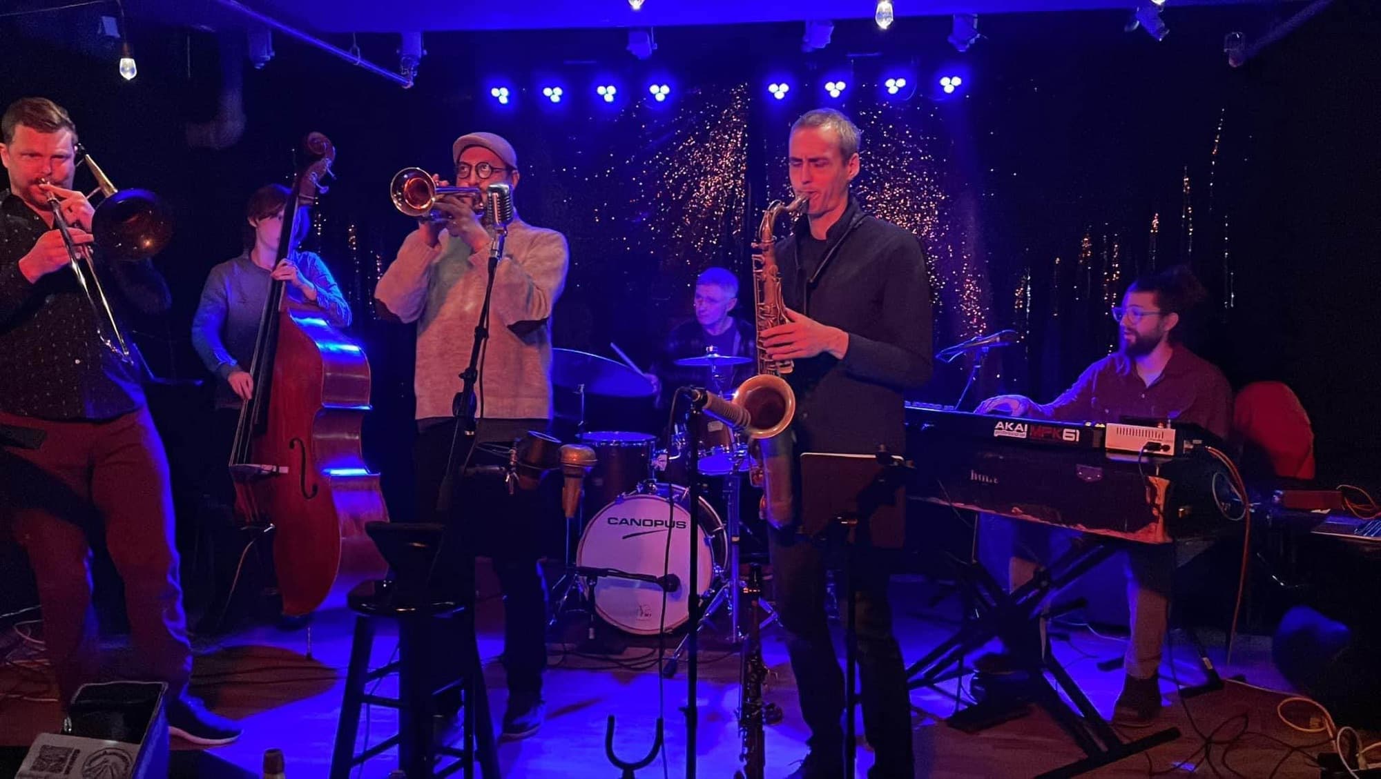 Jazz quintet performing under blue stage lights
