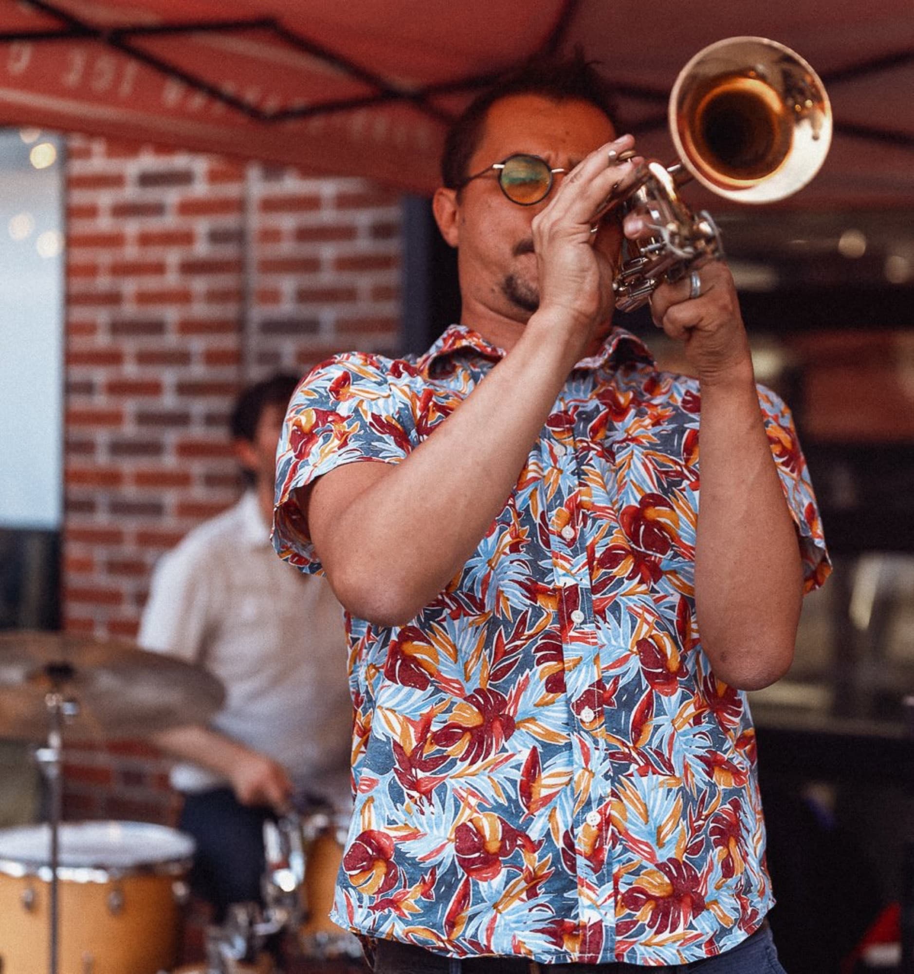 Reid Poole performing trumpet in a colorful shirt
