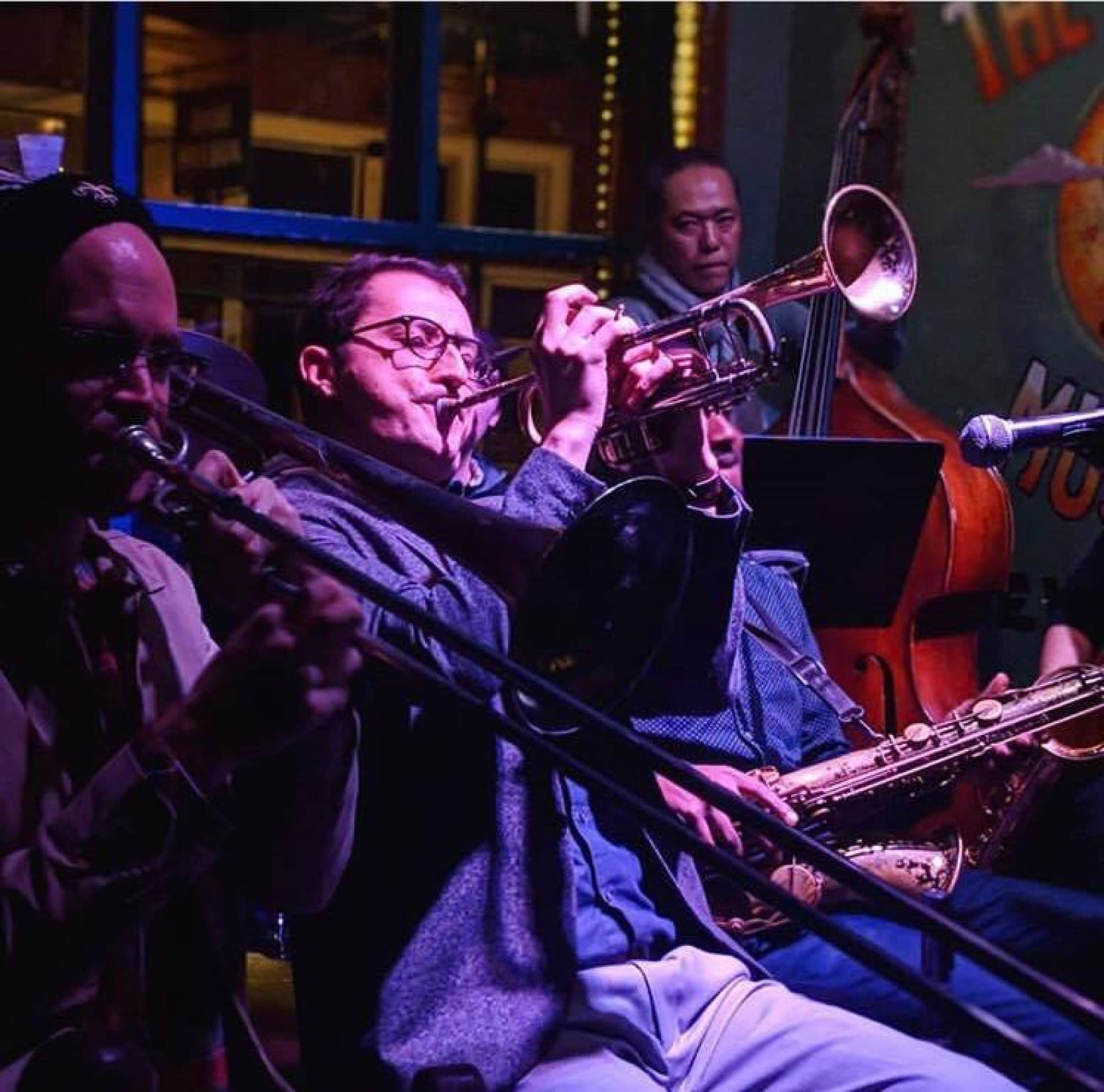 Reid Poole playing trumpet in a crowded New Orleans jazz club