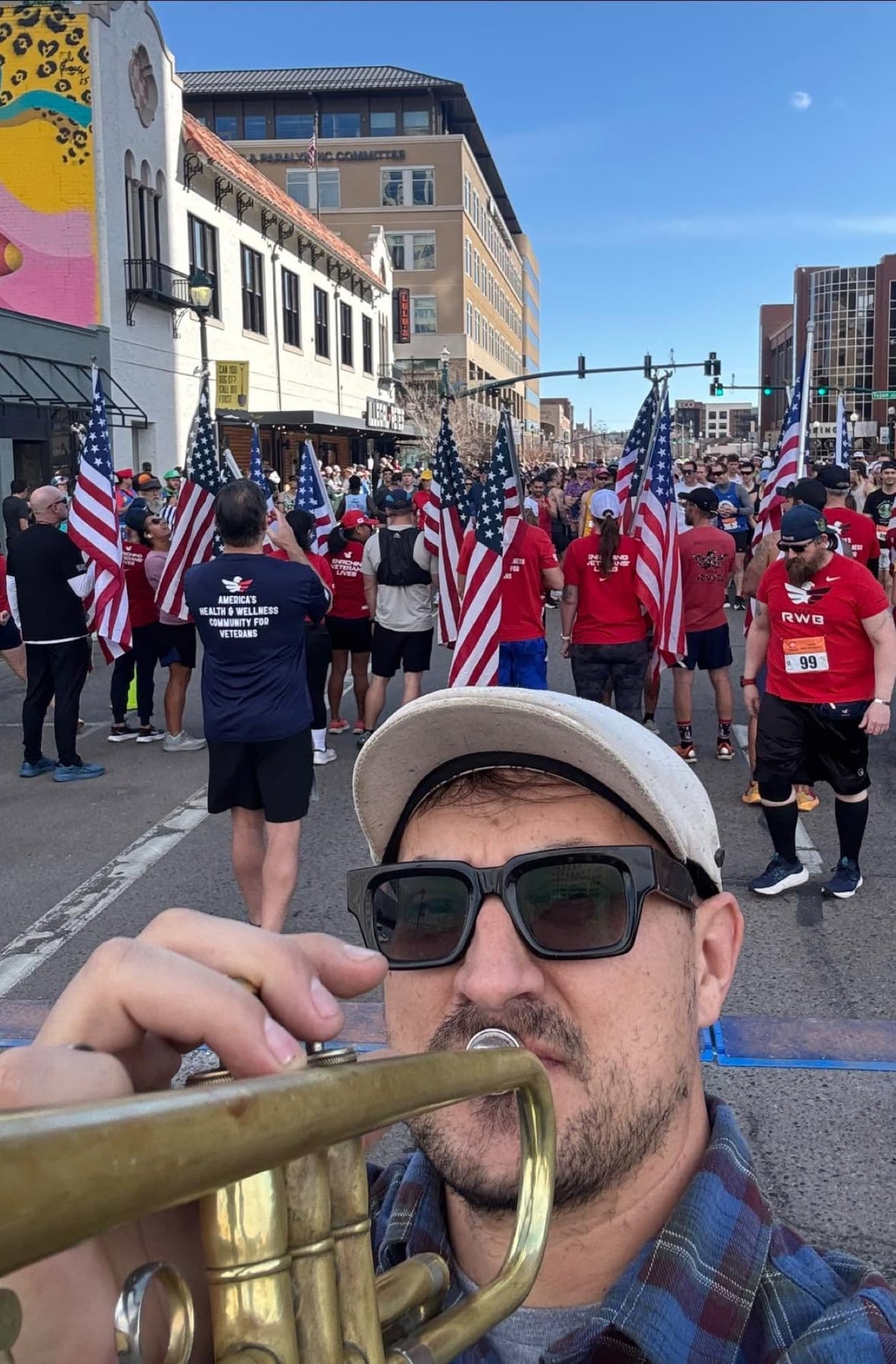 Reid Poole playing trumpet at the front of a community street race
